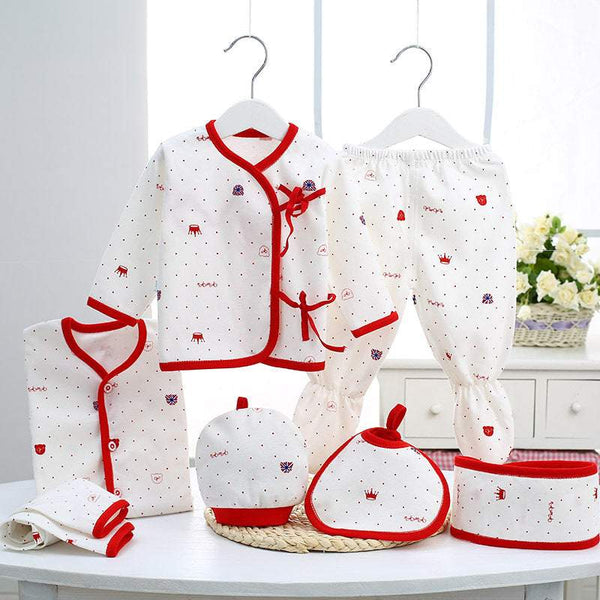 Pure Cotton Newborn Gift Set featuring infant clothes and accessories with red trim and small prints on white fabric.