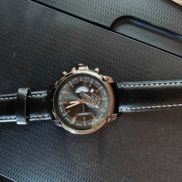 Men's sports pointer quartz watch with round dial and black leather strap on textured black surface