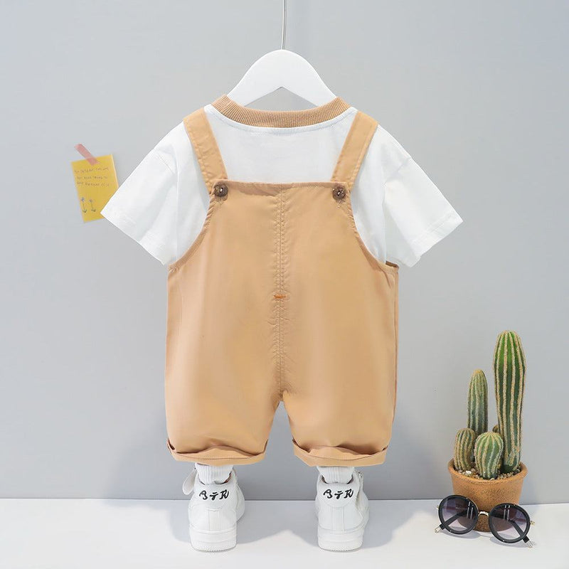 Children's cotton summer cartoon short-sleeved overall in khaki color with white t-shirt and sneakers on hanger.